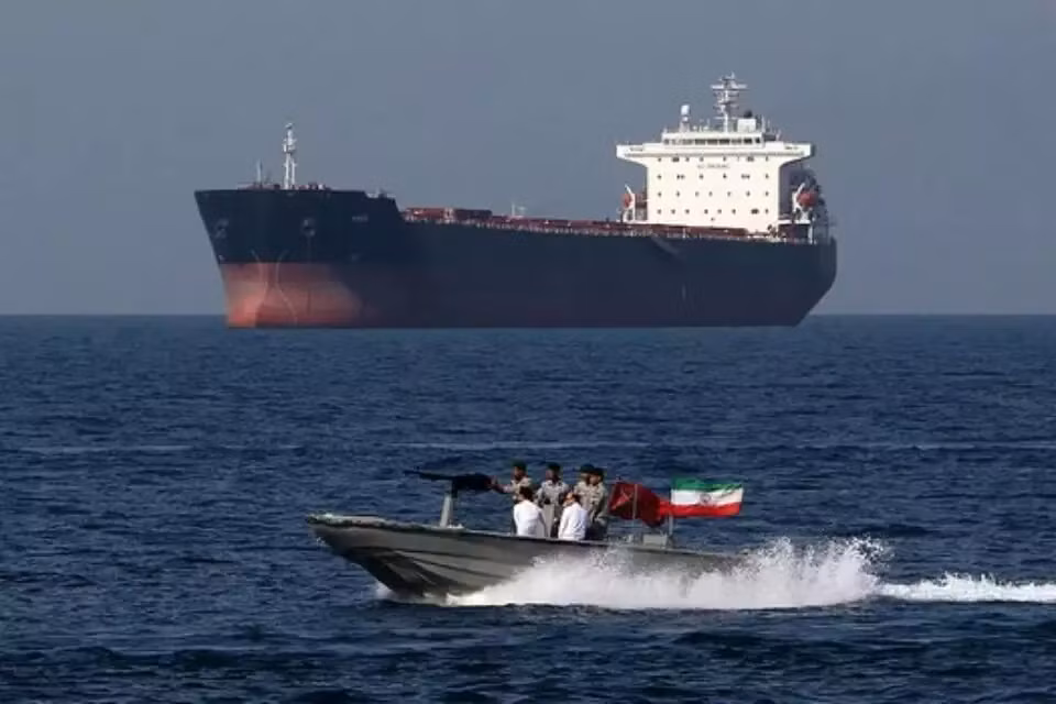 Một tàu nhỏ của Iran và một tàu hàng trên biển. Ảnh: Getty Images.