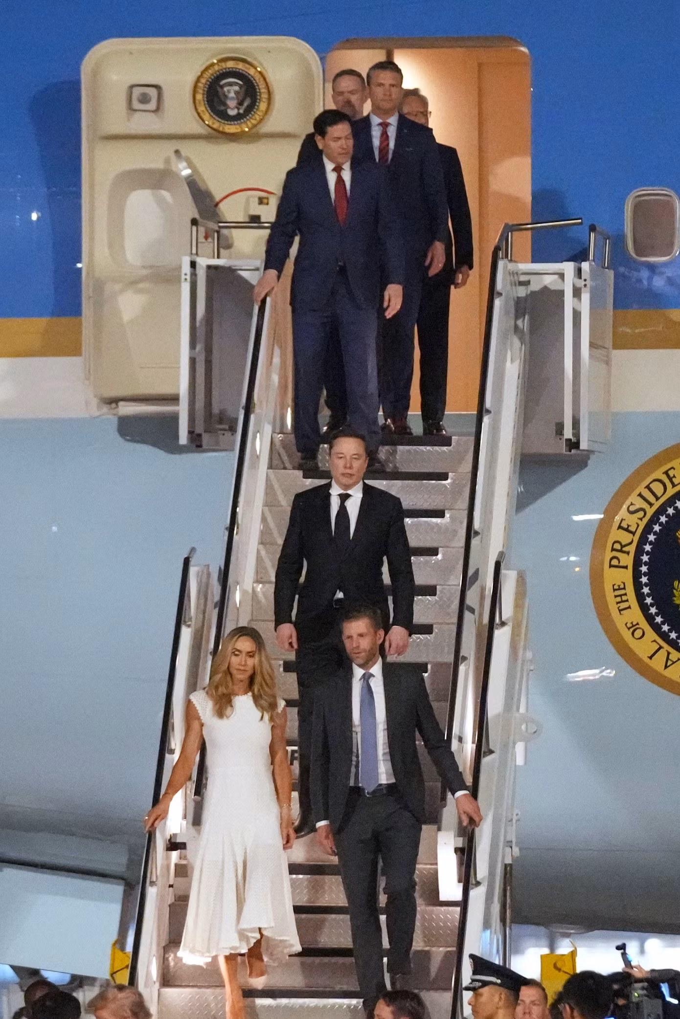 Tổng thống Mỹ Donald Trump đến Trung Quốc với một phái đoàn gồm nhiều quan chức cấp cao, phụ tá thân cận, lãnh đạo các doanh nghiệp, thậm chí cả các thành viên gia đình. Trong ảnh là Giám đốc điều hành (CEO) Tesla Elon Musk cùng con trai của tổng thống Eric Trump, và con dâu Lara Trump. (Ảnh: AP)