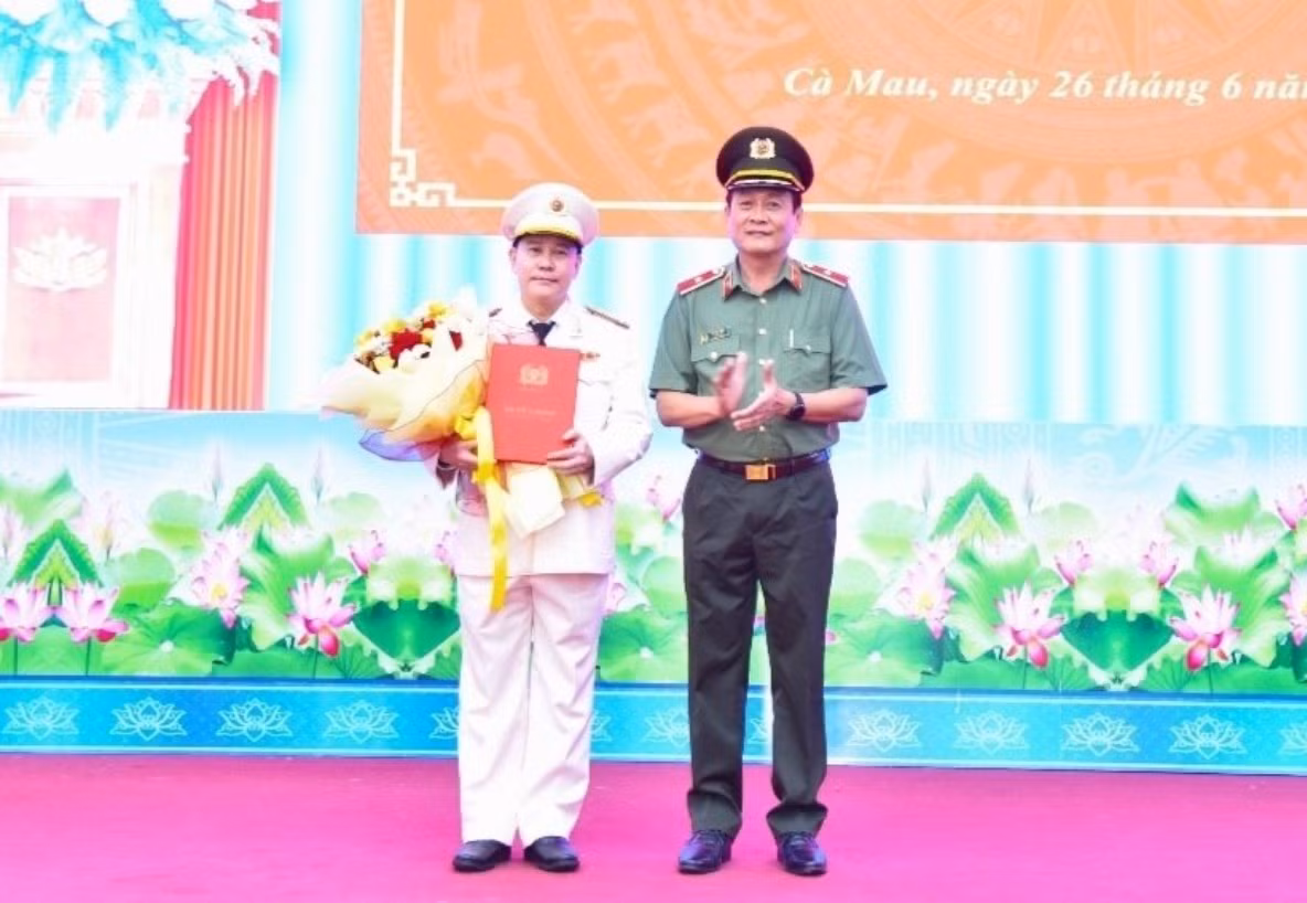 Thiếu tướng Hồ Việt Triều - Giám đốc Công an tỉnh Cà Mau trao quyết định cho Đại tá Lê Mạnh Hùng (trái).