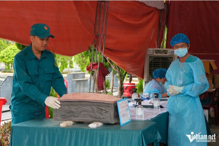 Lực lượng thực hiện nhiệm vụ lấy mẫu ADN tại Nghĩa trang liệt sĩ Trảng Bom. Ảnh: Hoàng Anh
