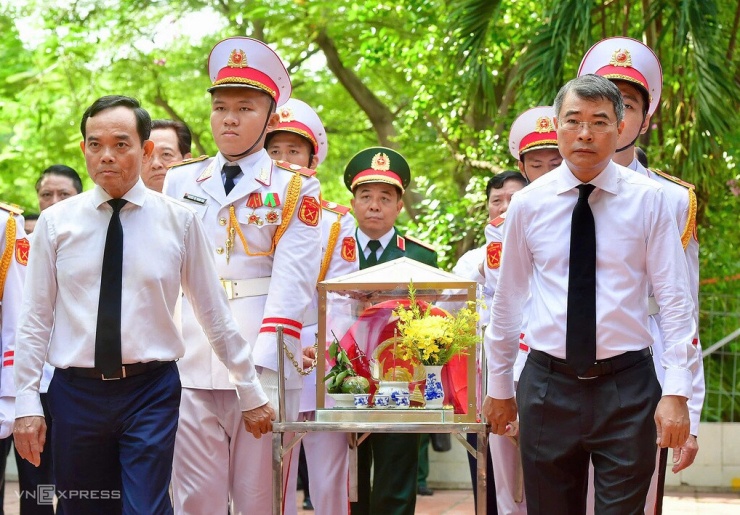Thủ tướng Lê Minh Hưng cùng Bí thư Thành ủy Trần Lưu Quang di quan hài cốt liệt sĩ được tìm thấy tại công viên Lê Thị Riêng về khu nhà truyền thống. Ảnh: Thanh Tùng