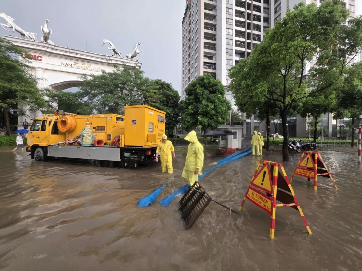 Nhân viên công ty Thoát nước Hà Nội túc trực tại đường Võ Chí Công (UDIC) làm nhiệm vụ khi mưa lớn. Ảnh: Quốc Bảo.