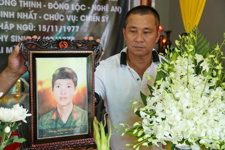 Ông Nguyễn Hữu Hợi bên di ảnh anh trai - liệt sĩ Nguyễn Hữu Năm. Ảnh: Đức Hùng