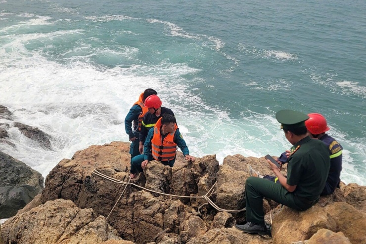 Lực lượng biên phòng, cảnh sát tìm kiếm cứu nạn trên ghềnh đá cheo leo ở Mũi Nghê. Ảnh: Quang Cường