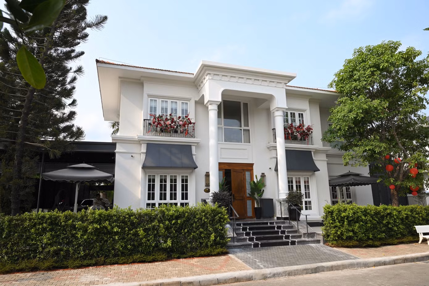 Chia sẻ với Tiền Phong , Thu Hương cho biết căn biệt thự được gia đình sử dụng từ năm 2017. Ngôi nhà nằm trong khu biệt thự Phú Gia, có một mặt hướng về hồ sinh thái và mặt còn lại nhìn ra đại lộ Nguyễn Văn Linh. Mặt tiền gây chú ý với gam trắng chủ đạo, hệ cột lớn, các đường phào chỉ và mái hiên mang phong cách tân cổ điển. Ảnh: NVCC .