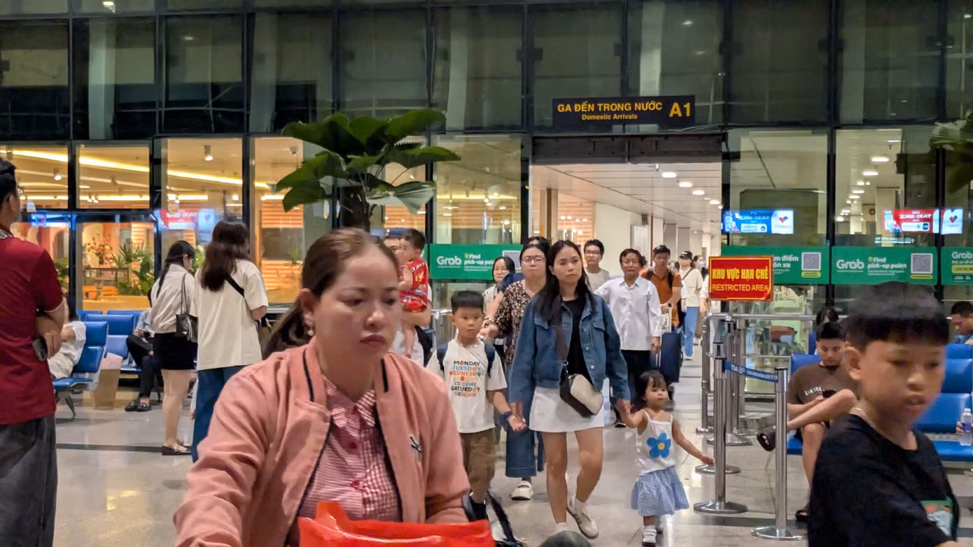 Hành khách xuống máy bay ở sân bay Tân Sơn Nhất tối qua. Ảnh: Hữu Huy.