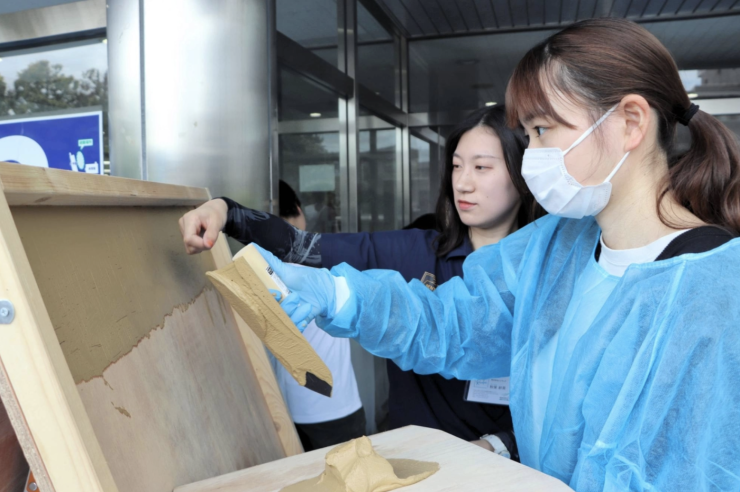 Hướng dẫn sinh viên Đại học Tohoku Bunka Gakuen cách trát vữa lên tường, tháng 6/2026. Ảnh: Kahoku Shimpo