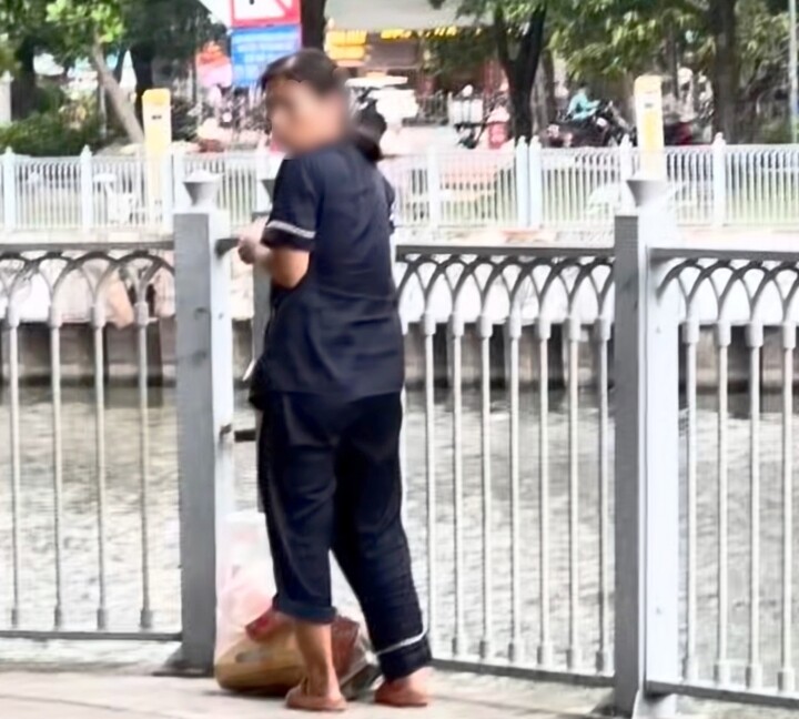 Người phụ nữ vô tư vứt rác xuống kênh Nhiêu Lộc - Thị Nghè. (Ảnh cắt từ clip).