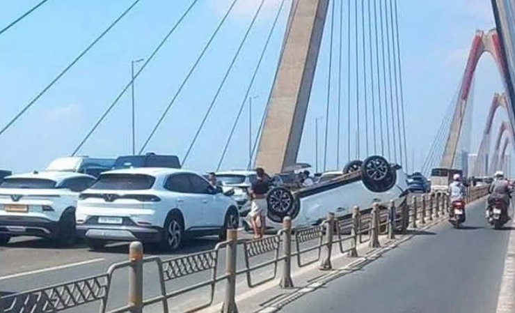 Một vụ tai nạn cách đó 100m khiến một xe ô tô 5 chỗ lật ngửa bụng giữa cầu Nhật Tân