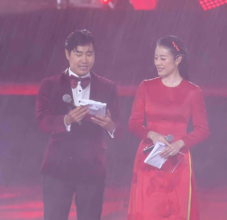 MC Nguyên Khang và MC Phí Linh quần áo sũng ướt khi cơn mưa xối xả đổ xuống trong giờ mở màn "Tổ quốc trong tim". (Ảnh: NVCC)