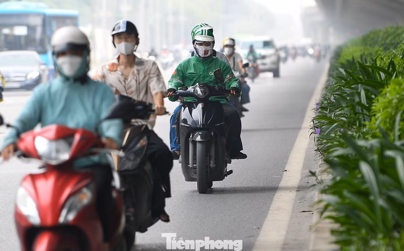 Trên đường Phạm Hùng, một trong những trục giao thông lớn ở phía Tây Thủ đô, lượng phương tiện đông từ đầu giờ sáng. Ánh sáng yếu xuyên qua lớp không khí đục, khiến toàn cảnh tuyến đường trở nên mờ nhòe.