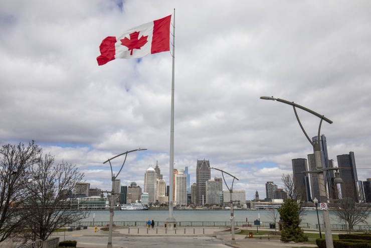Quốc kỳ Canada ở thành phố Windsor, bang Ontario ngày 1/4. Bên kia sông là thành phố Detroit, bang Michigan, Mỹ. Ảnh: AFP