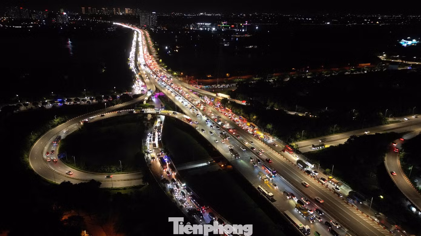Càng về phía cầu Thanh Trì, mật độ phương tiện trên vành đai 3 trên cao càng tăng. Nhiều ô tô mang biển kiểm soát ngoại tỉnh nối đuôi rời Hà Nội.