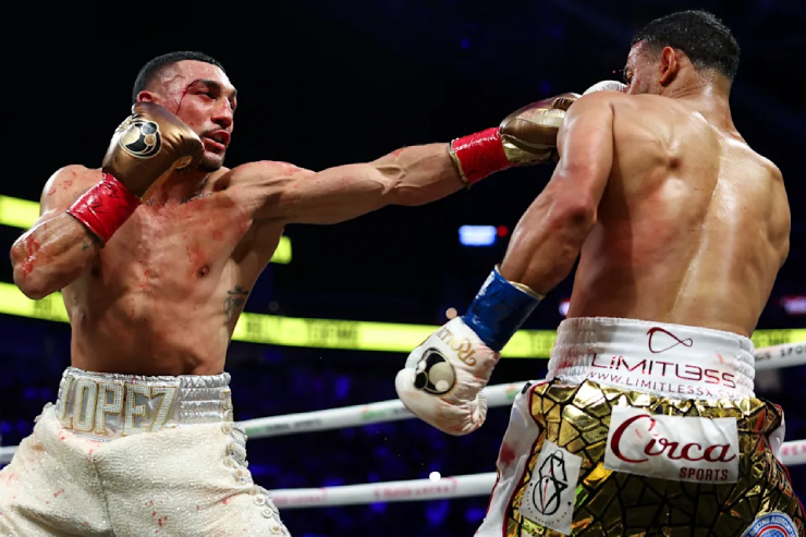 Teofimo Lopez (bên trái) vượt qua vết rách trên mặt để đánh bại Rolando Romero