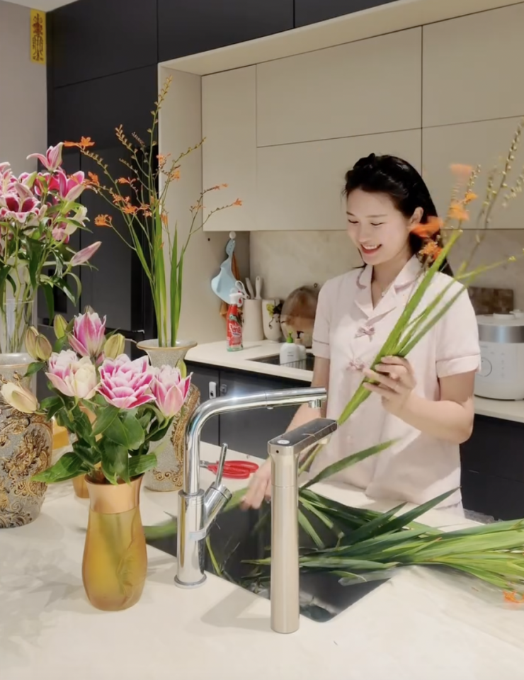 Không gian phía sau Hải My cũng nhanh chóng thu hút sự chú ý. Căn bếp được thiết kế hiện đại, tông màu sáng, gọn gàng và sang trọng. Trên bàn là những cành hoa và đồ dùng phục vụ việc trang trí, cho thấy nàng WAG đang tự tay chuẩn bị tổ ấm cho dịp Rằm tháng 7.
