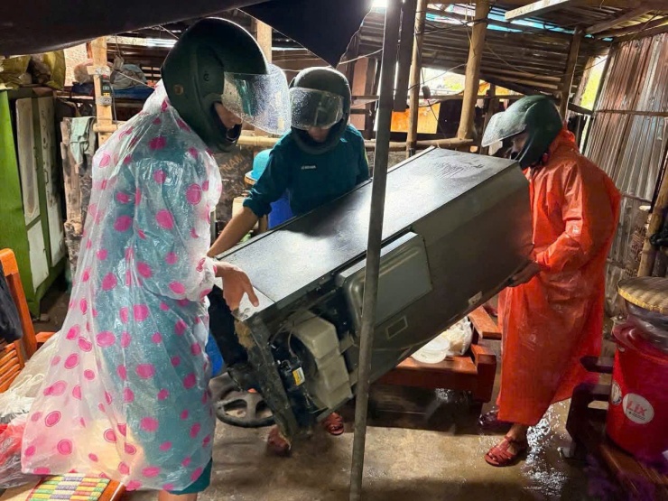 Các lực lượng chức năng hỗ trợ di dời tài sản cho người dân khu vực có nguy cơ sạt lở. Ảnh: G.X
