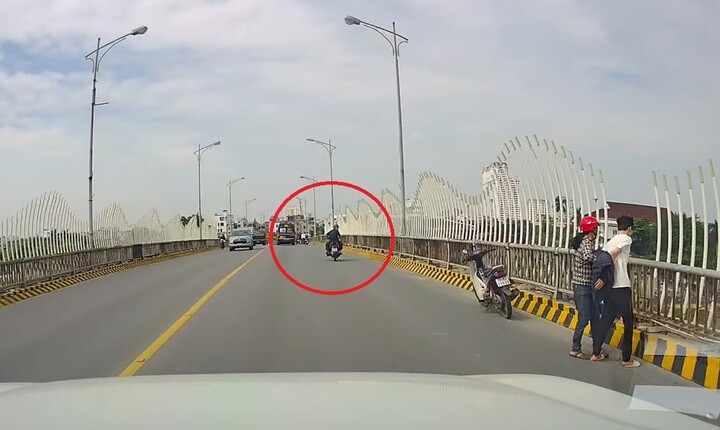 Thấy 2 mẹ con bà N. đang giằng co trên cầu, Thiếu tá Trần Văn Tùng ngoái lại theo dõi rồi quay lại khuyên can, giúp đỡ.