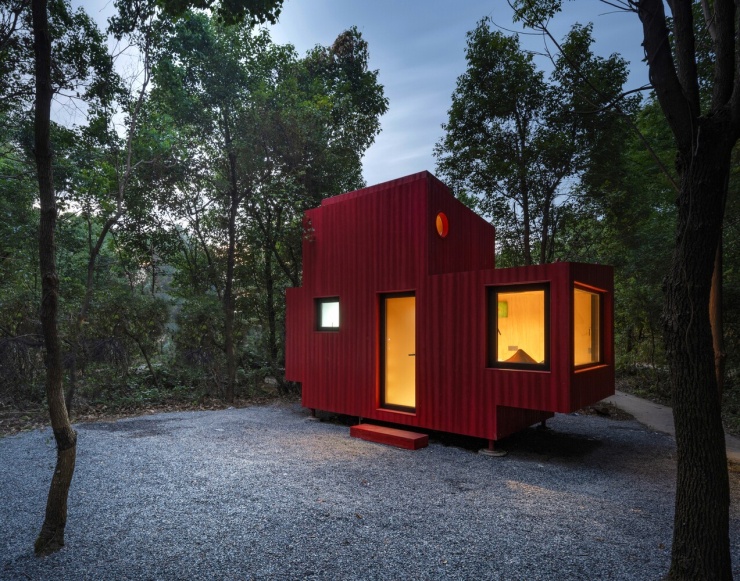 Căn nhà cabin có diện tích 20 m2, nằm giữa khu rừng tại Vũ Hán (Trung Quốc). Nhóm thiết kế chọn màu đỏ cho toàn bộ lớp vỏ bên ngoài, kết hợp hình khối kéo dài và các cửa sổ tròn lấy cảm hứng từ ô quan sát trên tàu ngầm.