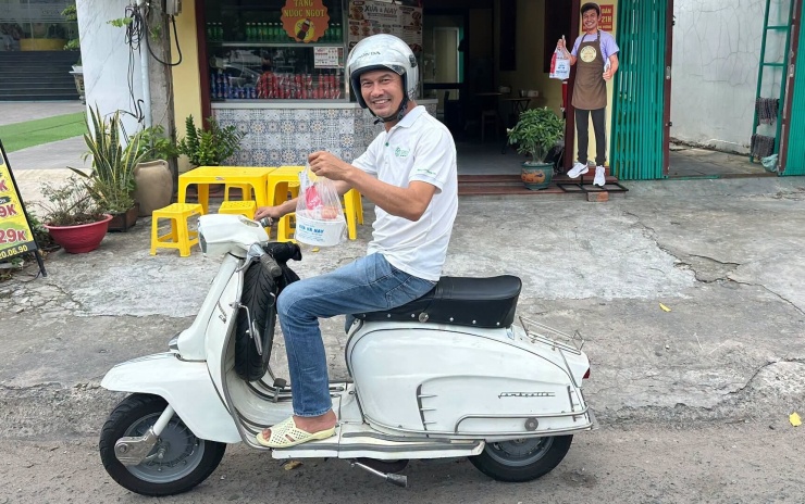 Tiết Cương chạy xe đi giao hàng.