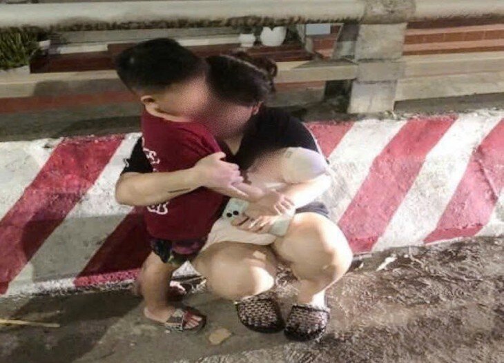 Hình ảnh người phụ nữ ôm 2 con nhỏ định nhảy cầu trong đêm ,may mắn được Công an phường Kiến An ngăn chặn kịp thời. Ảnh: Cơ quan Công an.