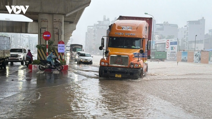 Các phương tiện chật vật vượt qua điểm ngập, nhiều người phải giảm tốc độ, thận trọng di chuyển qua những khu vực nước dâng cao.