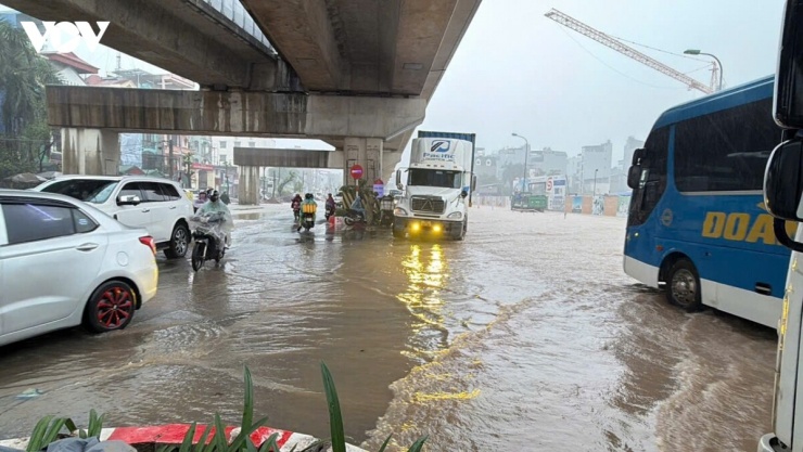 Các phương tiện nối đuôi nhau, di chuyển chậm qua điểm ngập sâu trên Quốc lộ 6 nhằm hạn chế nguy cơ chết máy và mất an toàn.