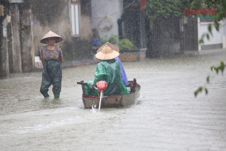 Sông Tích tràn bờ, dân ven đô Hà Nội chèo thuyền mua mì tôm, chăng lưới chắn rác trước nhà - 3