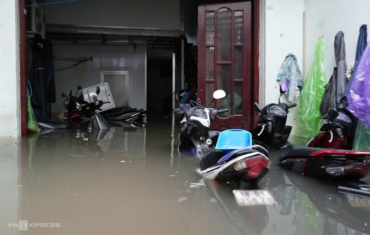 Xe cộ không thể đưa lên cao, ngâm trong nước. Nhiều gia đình mất điện, buộc phải đưa con cháu đi sơ tán khỏi những căn nhà đang ngập. Ảnh: Huy Mạnh