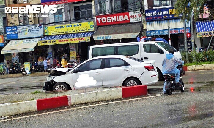 Xe taxi đang đậu gần đó bị va chạm hư hỏng nặng phần đầu.