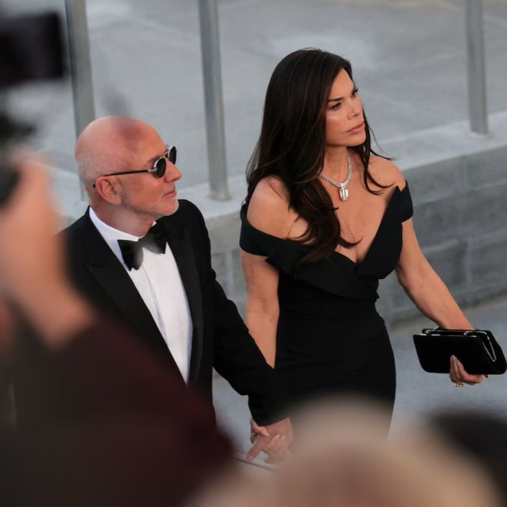 Jeff Bezos, Chủ tịch Amazon, đi cùng vợ Lauren Sanchez-Bezos. Cựu nhà báo 56 tuổi gây chú ý khi diện váy khoét sâu, đeo vòng cổ kim cương.