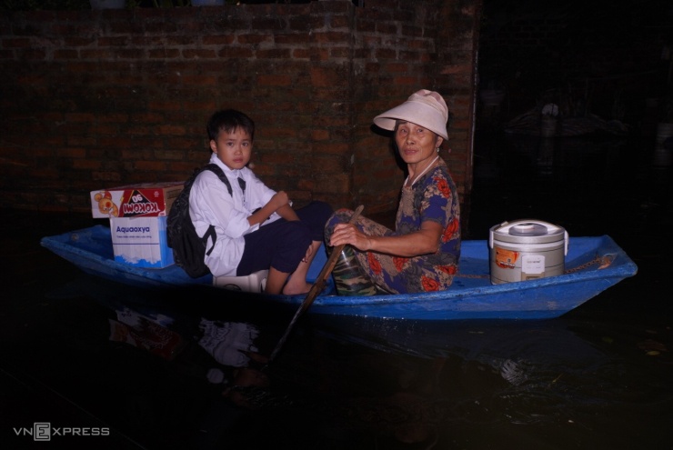 Người già và trẻ em thích nghi với cuộc sống vùng lũ. Ảnh: Nhật Anh