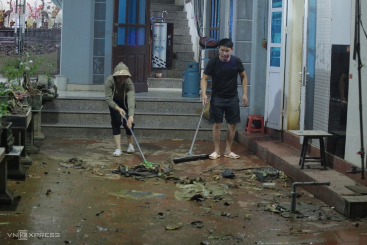 Người dân dọn nhà khi nước rút. Ảnh: Nhật Anh
