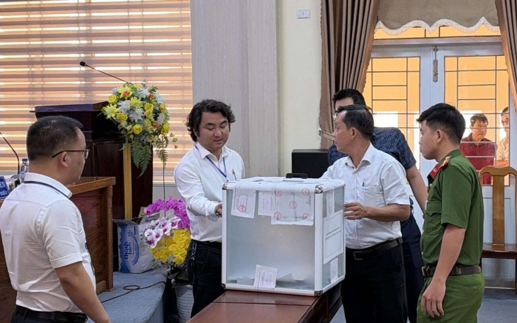 Các thành viên và đại diện cơ quan chức năng tham gia buổi đấu giá kiểm tra thùng bỏ phiếu đấu giá. Ảnh: CX
