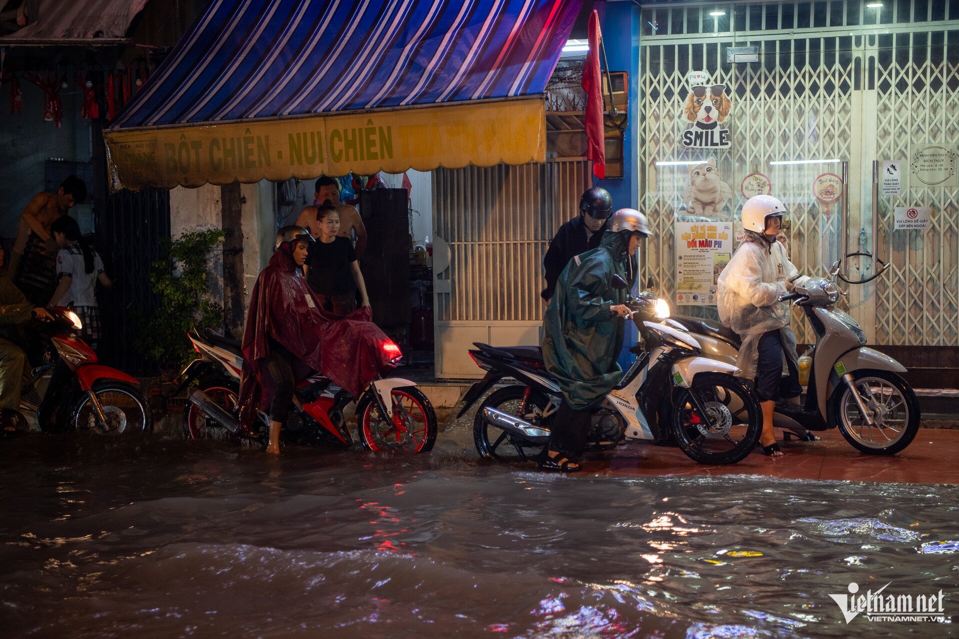 Người dân dừng chờ nước rút trên đường Lý Tế Xuyên. Một số người nôn nóng về nhà phải dắt bộ xe chết máy.