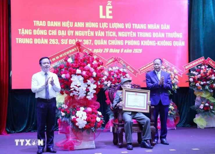Bí thư Tỉnh ủy Hưng Yên Phạm Quang Ngọc tặng hoa chúc mừng Anh hùng Lực lượng Vũ trang Nhân dân Nguyễn Văn Tích. Ảnh: TTXVN.