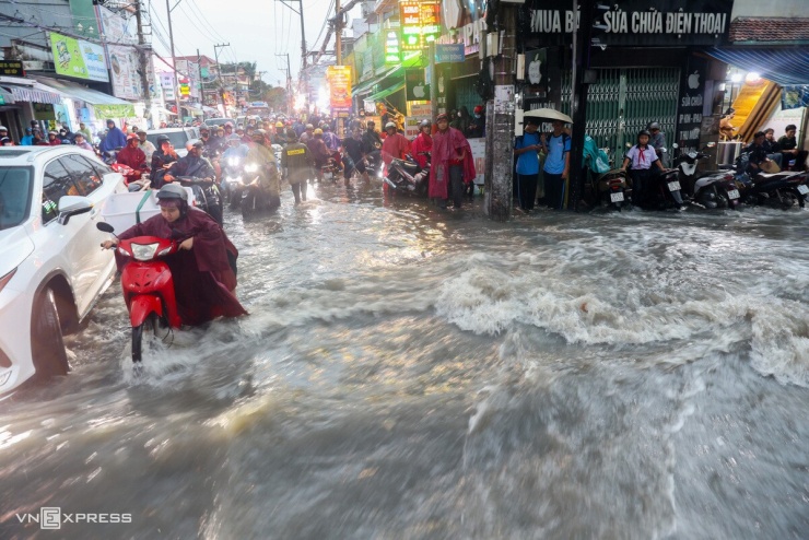 Mưa lớn trút xuống khu vực Thủ Đức đúng giờ tan tầm cũng khiến nhiều tuyến đường ngập sâu. Trên đường Tô Ngọc Vân, chỉ sau khoảng 10 phút mưa nặng hạt, nước đã dâng lút bánh xe, chảy xiết. Khu vực giao với đường Linh Đông ngập nặng nhất, dòng nước cuồn cuộn gây khó khăn cho người đi đường.