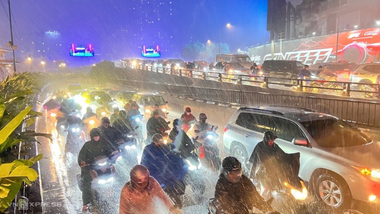 Xe cộ ùn ứ trên đường Tôn Đức Thắng, cầu Ba Son và cầu Khánh Hội (quận 1 và 4 cũ). Mưa tạt kèm gió mạnh khiến người đi xe máy di chuyển khó khăn.