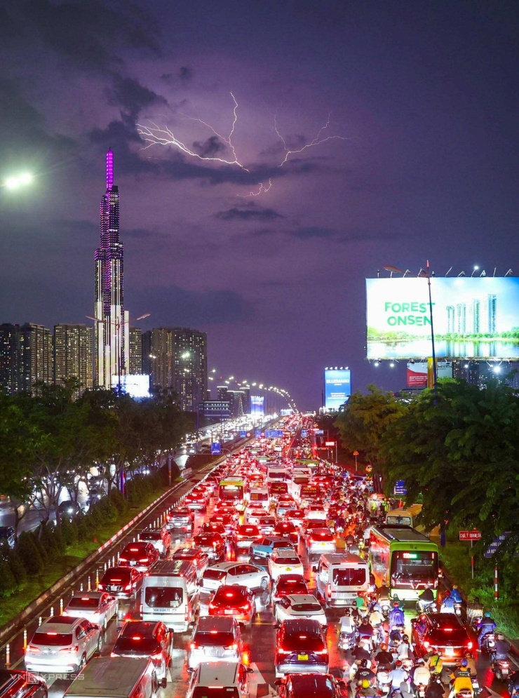 Tia sét trên bầu trời trung tâm TP HCM, bên trái là tòa nhà Landmark 81 tầng, nhìn từ cầu bộ hành ga metro Thảo Điền, tối 1/10. Ảnh: Quỳnh Trần