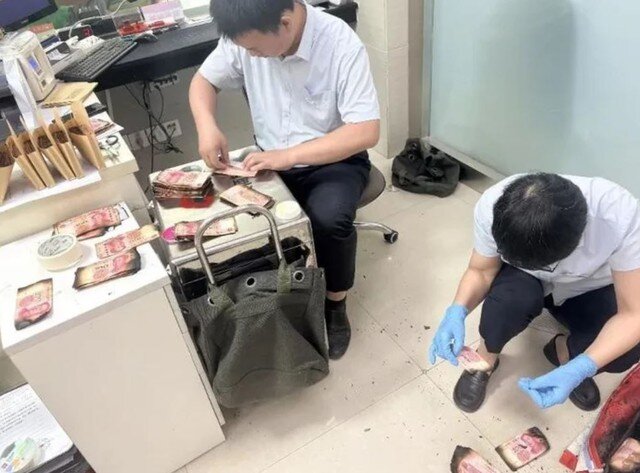 Nhân viên ngân hàng kiêm đếm số tiền bị cháy.