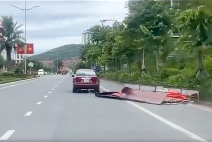 Chiếc ô tô kéo khung sắt, tấm tôn trên đường. Ảnh chụp màn hình