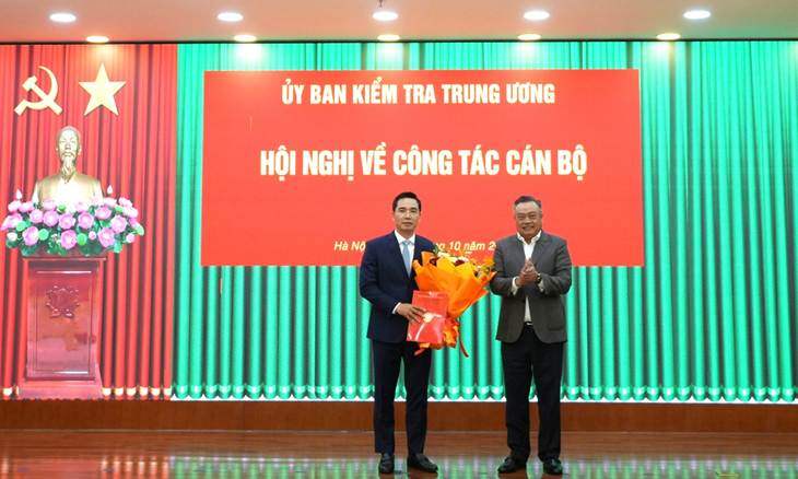 Ông Trần Sỹ Thanh, Chủ nhiệm Ủy ban Kiểm tra Trung ương trao quyết định và tặng hoa chúc mừng ông Trần Văn Phúc. Ảnh: ĐCS.