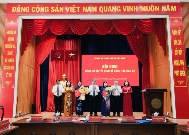 Phó Bí thư Thành ủy TP.HCM Nguyễn Phước Lộc (giữa) trao quyết định và hoa chúc mừng 2 tân Phó Bí thư chuyên trách Đảng ủy MTTQ, các đoàn thể thành phố nhiệm kỳ 2025-2030. Ảnh: MTTQ TP.HCM.