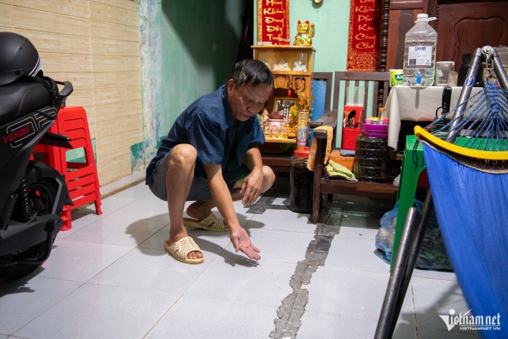 Dù đã nhiều lần nâng nền nhà, lắp vách ngăn để ngăn nước tràn vào, gia đình ông Chung vẫn đau đầu tìm cách chống ngập mỗi mùa triều cường tại TPHCM. Trong ảnh, ông Chung đang chỉ vào vị trí nước dâng từ dưới nền nhà mỗi mùa triều cường.