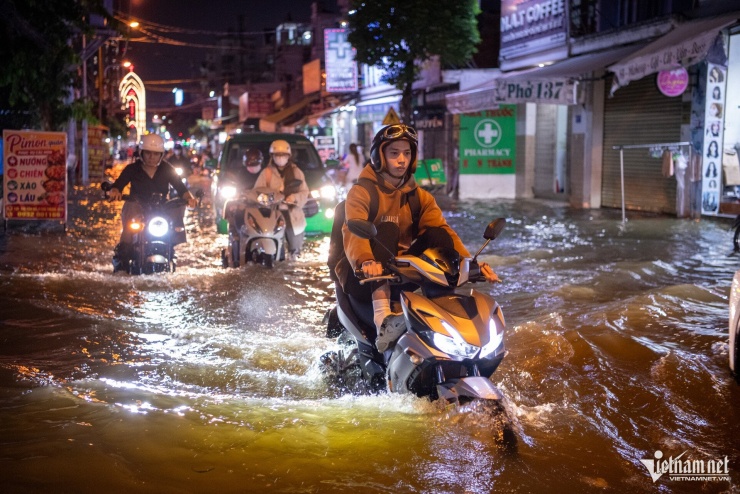 Đường Bùi Văn Ba ngập sâu, nước dâng cao như biến thành sông, khiến người dân chật vật về nhà. 