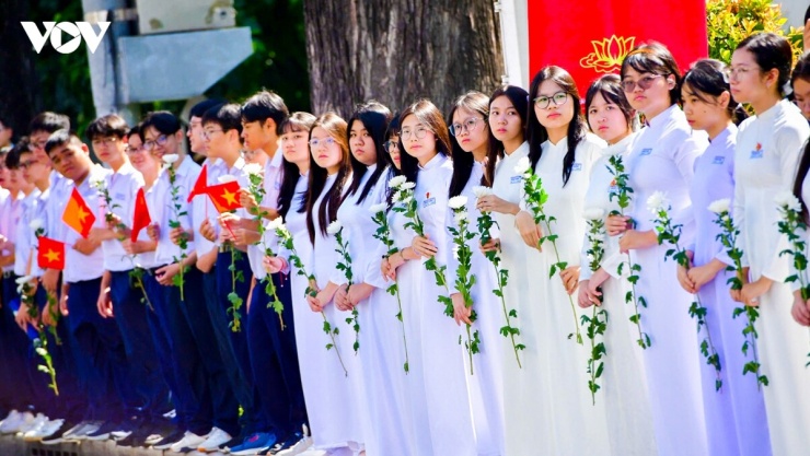Người dân đứng bên đường, từ người già đến người trẻ, cả những bạn thanh thiếu niên, tay cầm hoa trắng, mắt ngấn lệ tiễn đưa 731 hài cốt liệt sĩ về nơi an nghỉ.