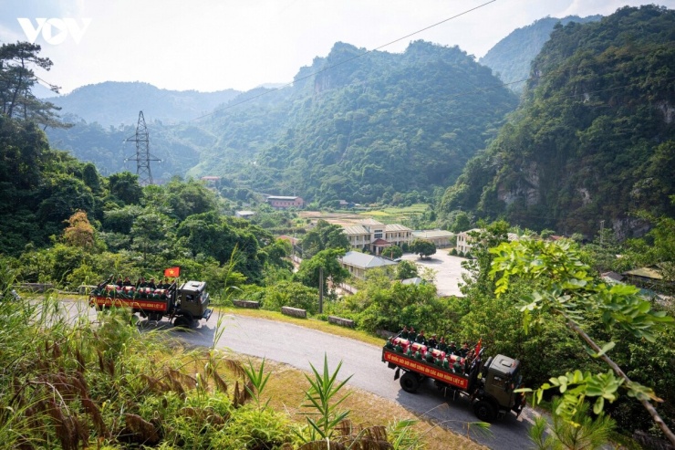 Sau nghi thức dâng hương, mặc niệm và tiễn biệt, các hài cốt liệt sĩ lần lượt được đưa lên xe, bắt đầu hành trình về Nghĩa trang Liệt sĩ Quốc gia Vị Xuyên. Dưới bầu trời biên cương, hai bên đường, đông đảo người dân đứng trang nghiêm, hướng về đoàn xe với lòng thành kính. Những lá cờ đỏ sao vàng phấp phới trong gió, những ánh mắt đỏ hoe, những giọt nước mắt lặng lẽ rơi thay lời tri ân gửi đến các Anh hùng liệt sĩ. Sau bao năm nằm lại giữa núi rừng, các anh đang trở về trong vòng tay đồng đội, trong tình cảm và lòng biết ơn sâu nặng của Đảng bộ, chính quyền và Nhân dân. 