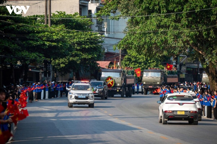Từ Quảng trường 26/3, phường Hà Giang 1 theo Quốc lộ 2, đoàn xe chở hài cốt liệt sĩ tiếp tục hành trình trong sự đón chào trang nghiêm của nhân dân. Dọc hai bên đường, người dân, đoàn thanh niên, các em học sinh cầm cờ Tổ quốc đứng lặng, hướng về đoàn xe với sự tri ân thành kính tiễn đưa các anh về nơi an nghỉ. Sắc đỏ của những lá cờ hòa cùng không khí trầm mặc, xúc động, làm nên hình ảnh đẹp về lòng biết ơn của nhân dân đối với những người đã hiến dâng tuổi xuân cho Tổ quốc.