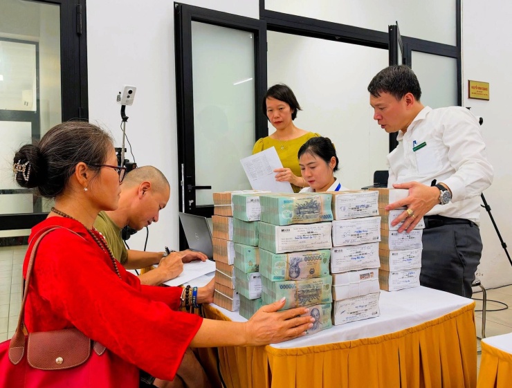 Người dân nhận tiền đền bù, giải phóng mặt bằng. Ảnh: Nguyên Bảo