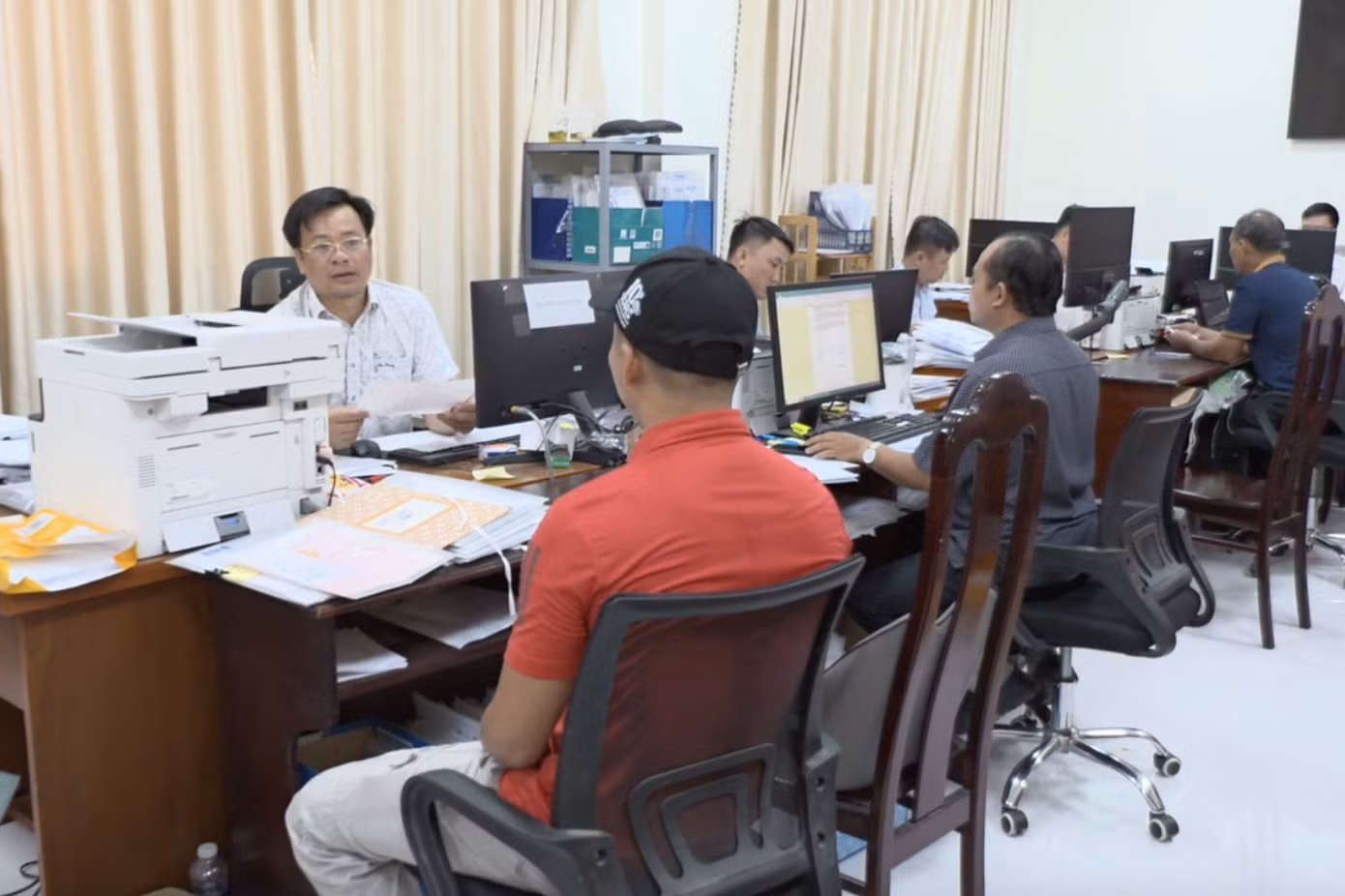 Cán bộ Văn phòng Đăng ký đất đai hướng dẫn người dân cấp sổ đỏ.