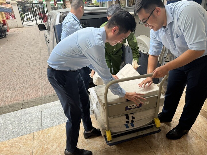 Nhân viên ngân hàng giúp người dân mang tiền về nhà an toàn.
